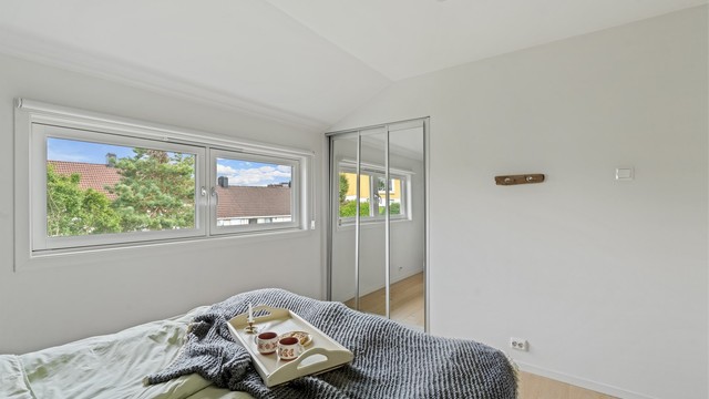 Soverom i 2. etasje med skyvedørsgarderobe med speilfronter.
