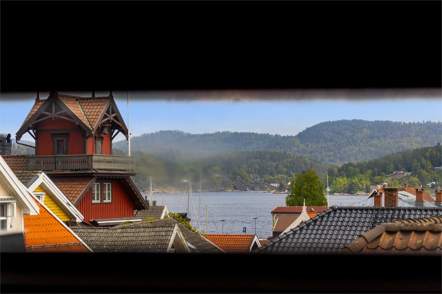 Utsikt mot Eidangerfjorden og den gamle brannstasjonen fra et mindre vindu i gangen i 3. etasje.