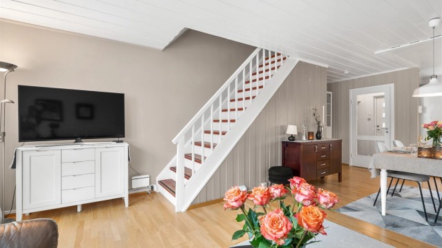 Stuen har laminatgulv, kombinasjon av veggpaneler, slette vegger og paneler i himling