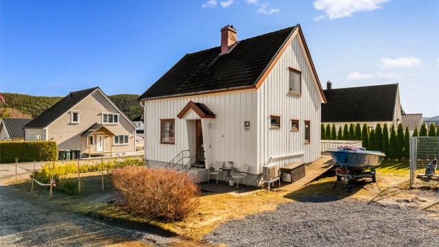 Tomten er opparbeidet med hekk mot nabo og veien. Gruset parkering i tillegg til garasje.