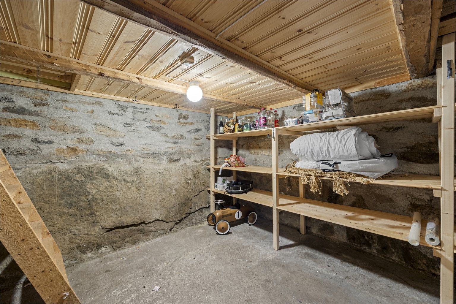Kjeller med grunnmur av naturstein og betong, gir gode lagringsmuligheter. Tilgang fra stue og utvendig.