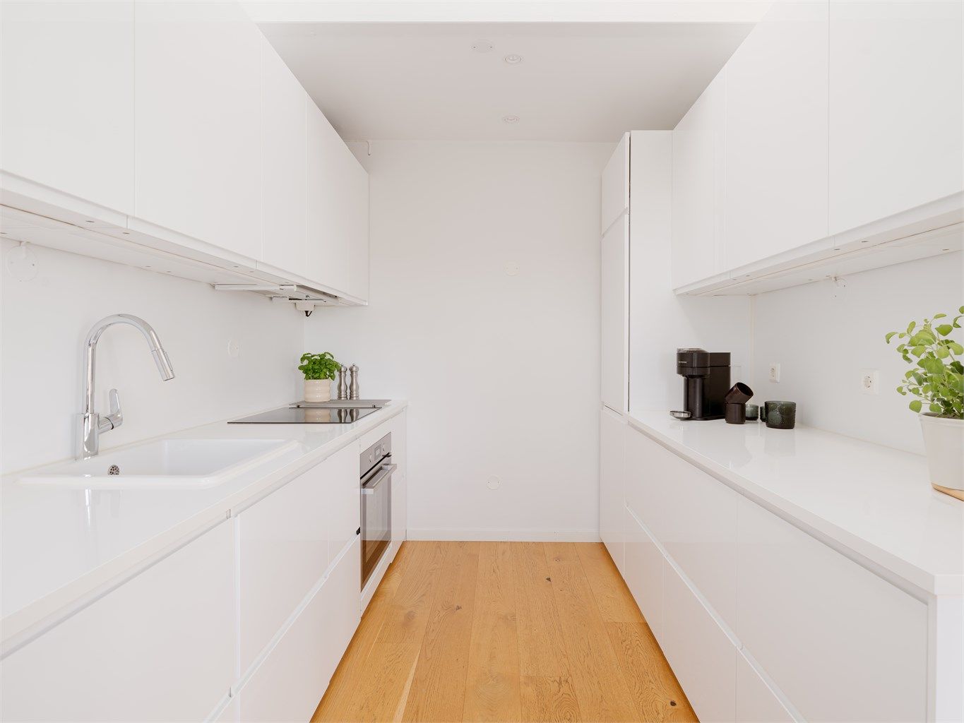 Det er rikelig med oppbevaringsplass i både skuffer og skap, og den gode benkeplassen gjør matlagingen enkel. Hvitevarene er sømløst integrert i innredningen.