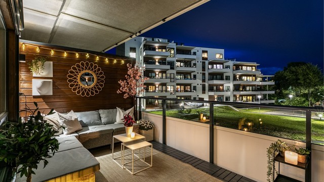 Leiligheten ligger i andre etasje, med veranda vendt mot sør. Verandaens skjermende overbygg både luner og utvider bruksmulighetene.