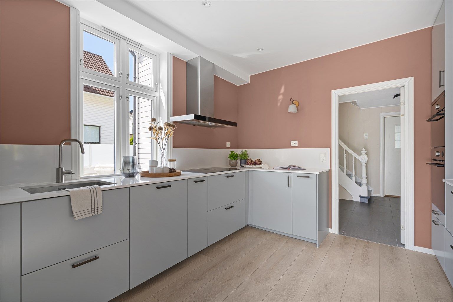 Flott og moderne kjøkken fra IKEA som var nytt i 2021. Innredningen er i lys grått med hvit kompositt benkeplate. 