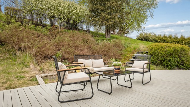 Fin uteplass på terrasseplatting med plass til flere sitteområder