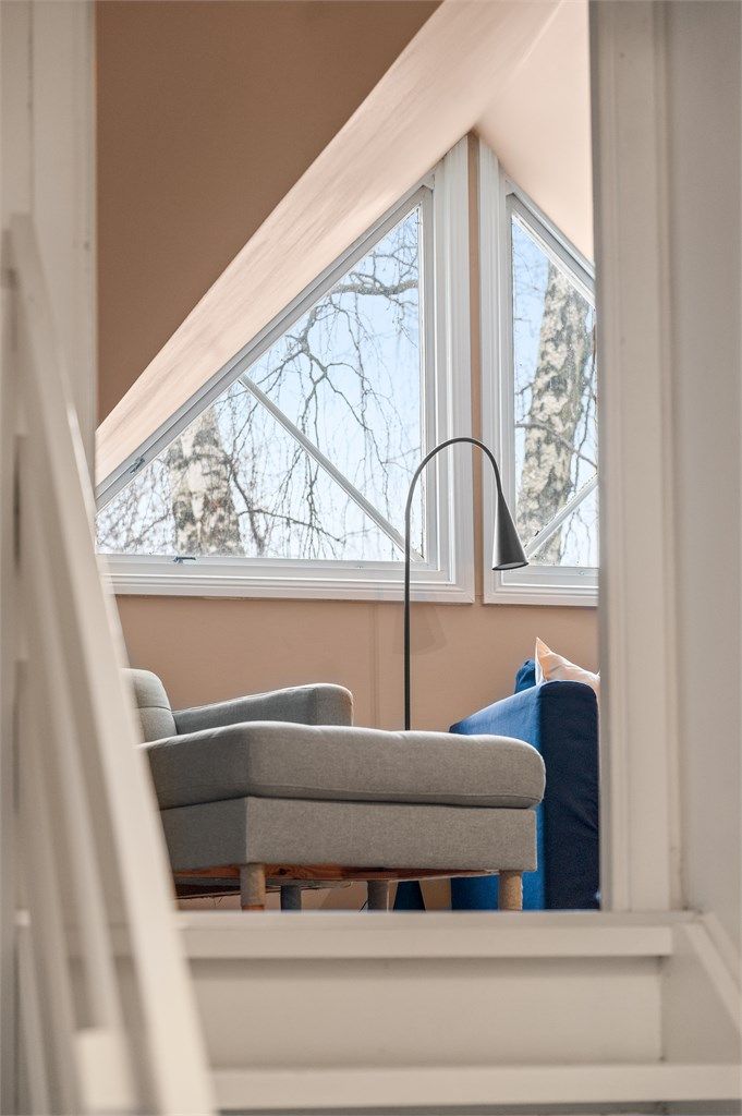 Under sjarmerende trekantvinduer, finner du boligens loftstue som i dag benyttes som tv-stue.