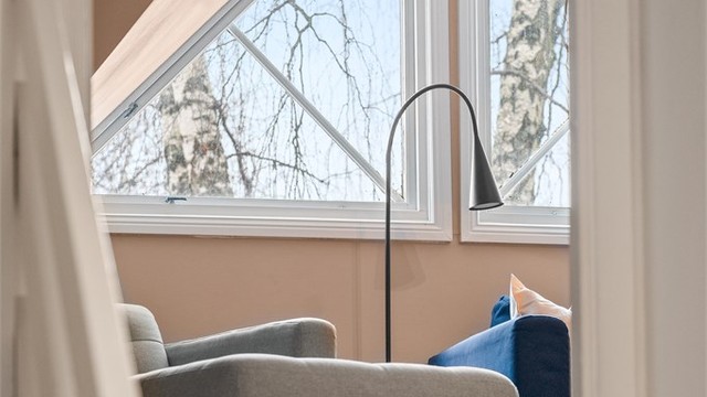 Under sjarmerende trekantvinduer, finner du boligens loftstue som i dag benyttes som tv-stue.