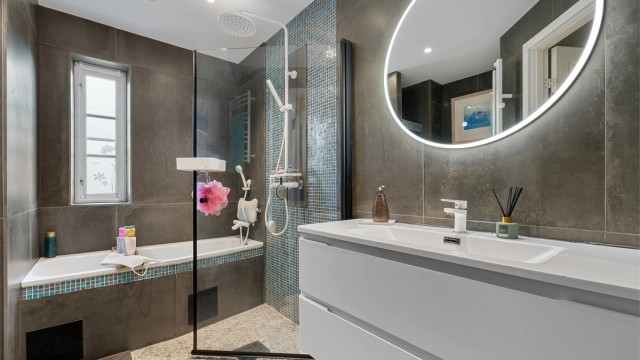 Badet inneholder både dusjhjørne med regnfallsdusj, og badekar med vegghengt armatur.