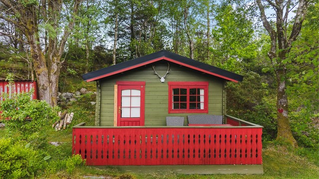 På tomten står et frittstående anneks med egen terrasse, samt boder for oppbevaring.