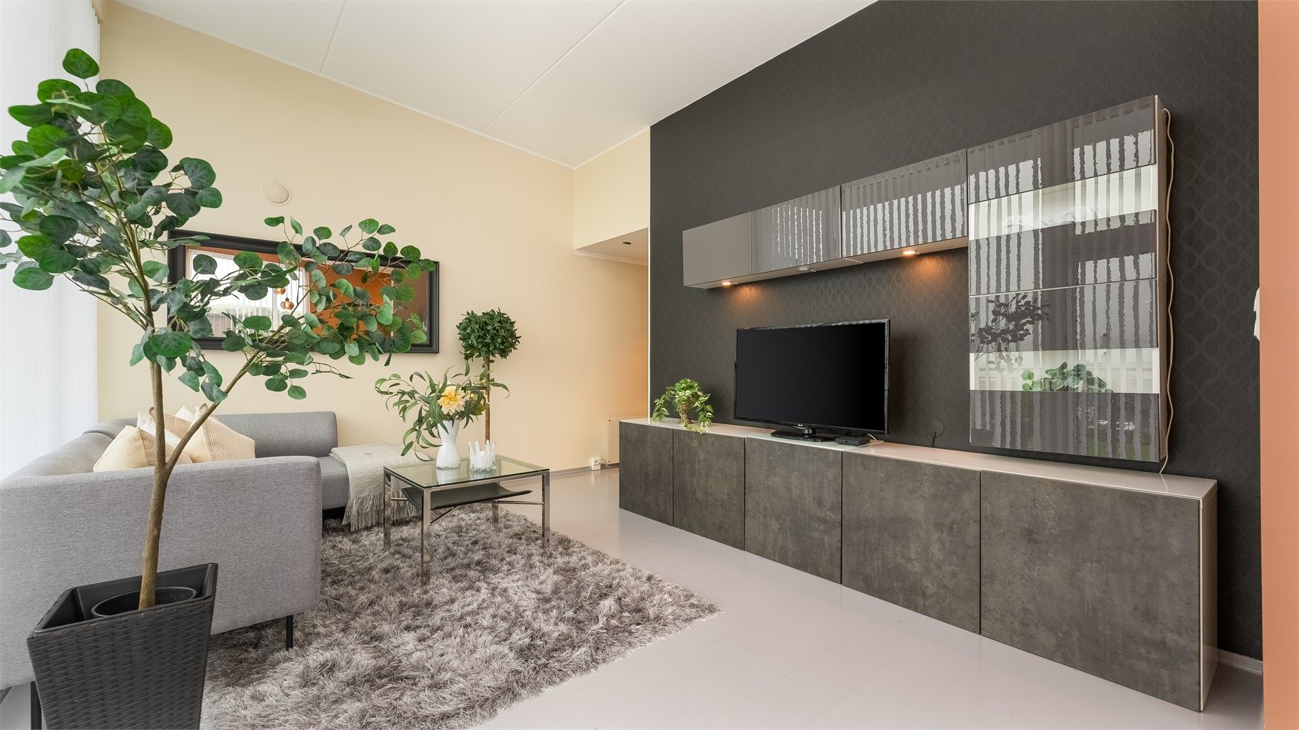 En hel vegg er dedikert til mediemøbel, som gir gode oppbevaringsmuligheter.