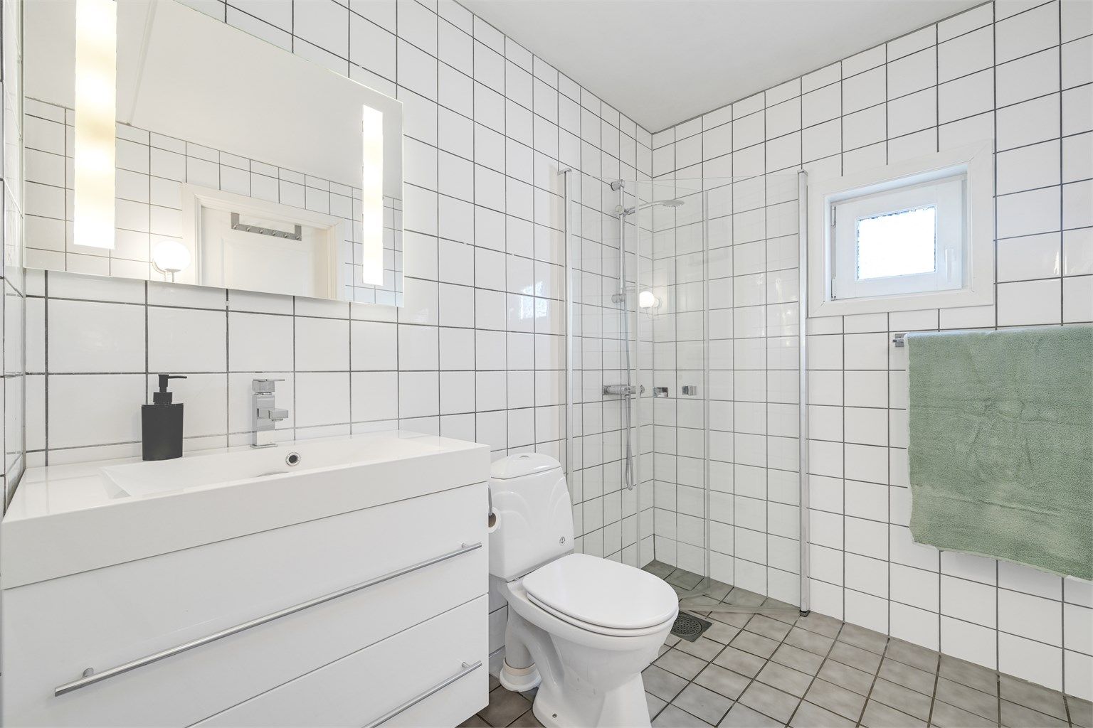 Badet i første etasje har flislagte overflater på gulv og vegger.