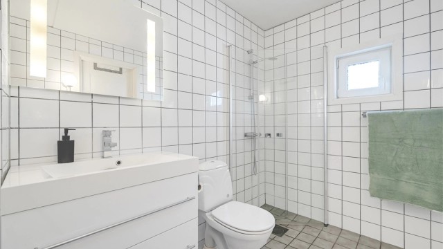 Badet i første etasje har flislagte overflater på gulv og vegger.