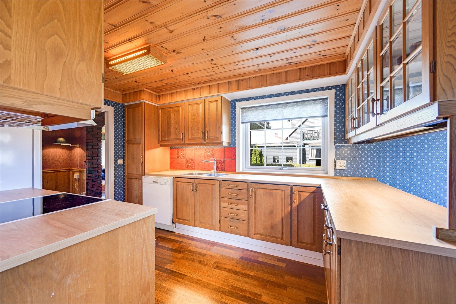 Innredningen har en kombinasjon av åpne hyller og overskap med glassdører.