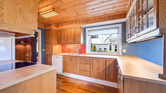 Innredningen har en kombinasjon av åpne hyller og overskap med glassdører.