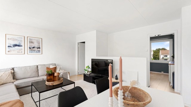 Leiligheten oppleves svært lys med hvitmalte flater og pent laminatgulv. Stuen er romslig med plass til stor sofagruppe og spisebord.