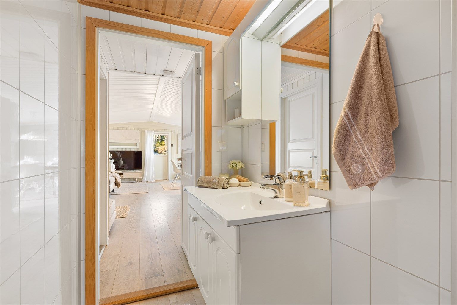 Badet er på 3 kvm og innredet med servantskap med overskap og speil med lys. 