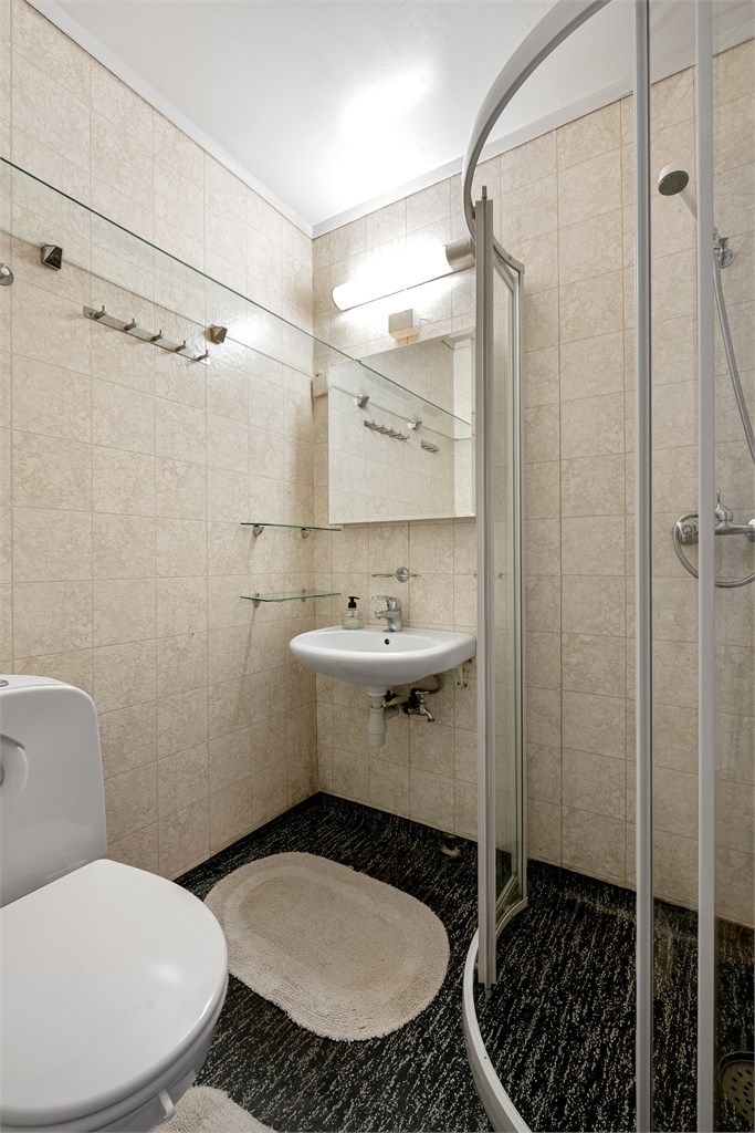 Badet i underetasjen er fra byggeåret og har gulvvarme, dusj, toalett og servant.