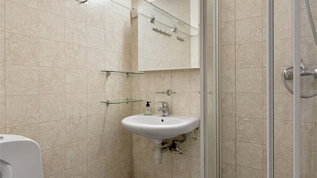 Badet i underetasjen er fra byggeåret og har gulvvarme, dusj, toalett og servant.