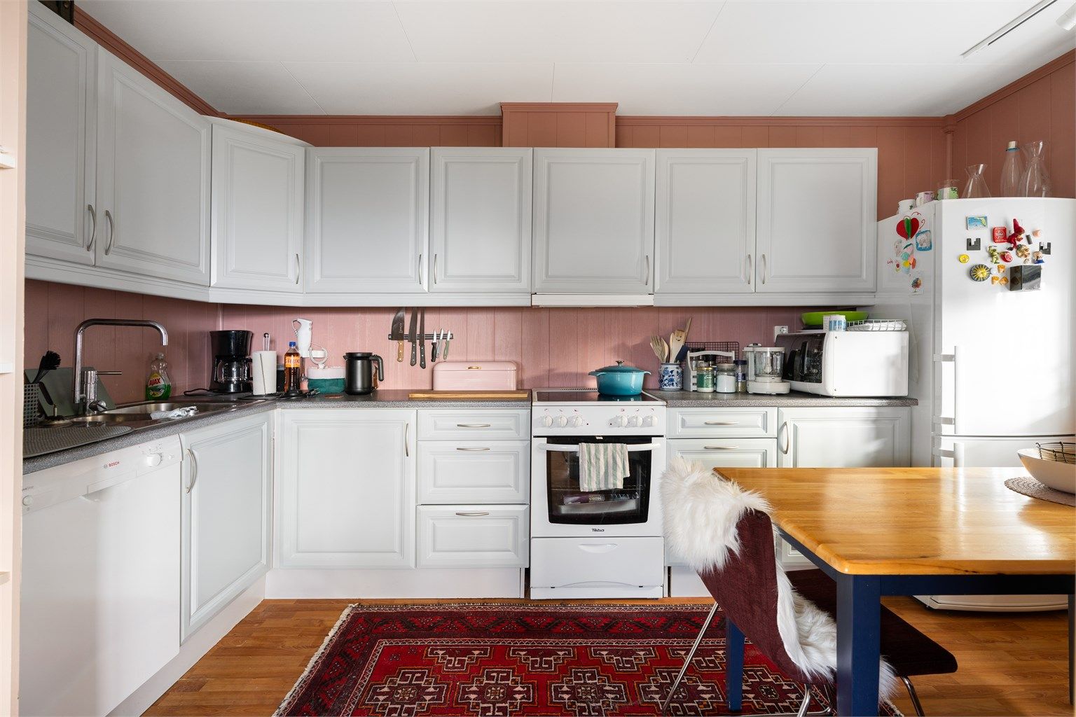 Kjøkkenet er pent innredet med profilerte fronter samt benkeplate av laminat og har frittstående komfyr, oppvaskmaskin og kjøleskap med fryser.