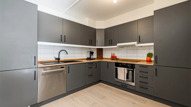 Innredningen er fra IKEA og består av malte, slette fronter med benkeplate av tre.