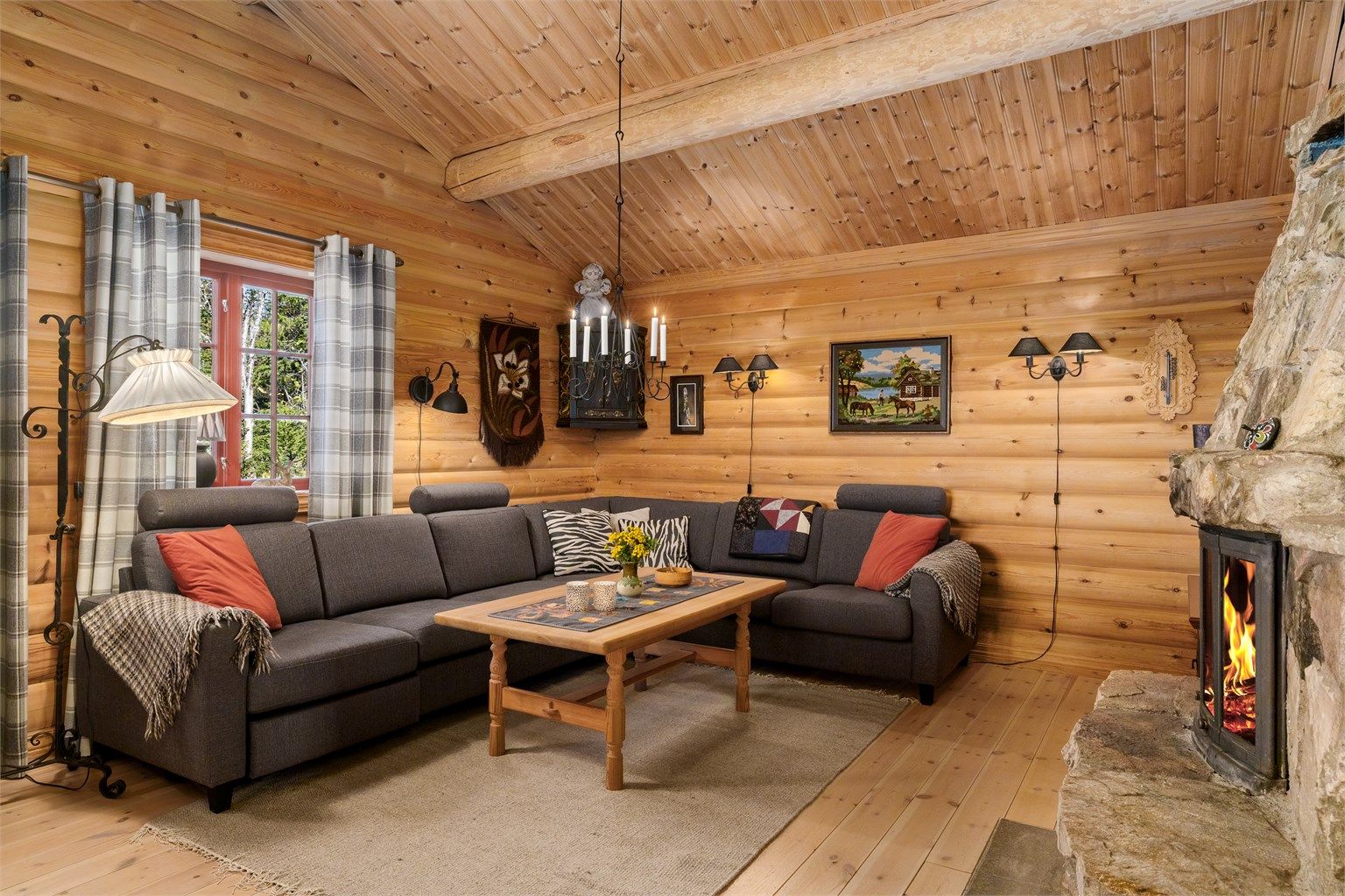 En romslig sofakrok inviterer til samvær foran peisen på kjølige kvelder.