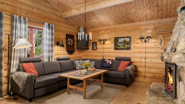 En romslig sofakrok inviterer til samvær foran peisen på kjølige kvelder.