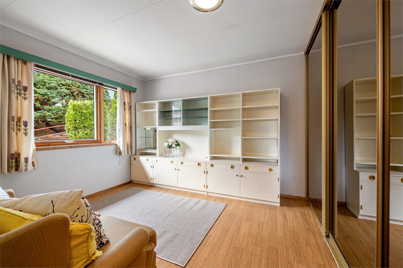 Soverom innredet med skyvedørsgarderobe med speilfronter.
