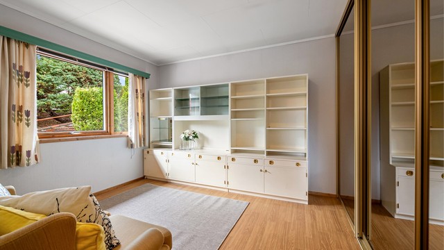 Soverom innredet med skyvedørsgarderobe med speilfronter.