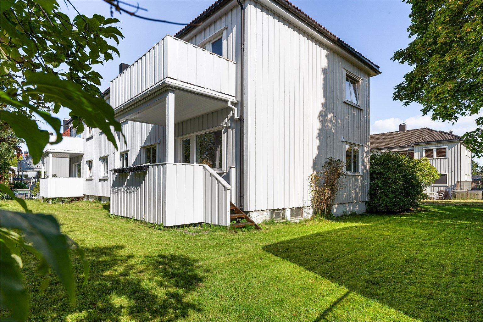 Sameiets tomt er pent opparbeidet med  plenareal, grus og diverse beplantninger. 