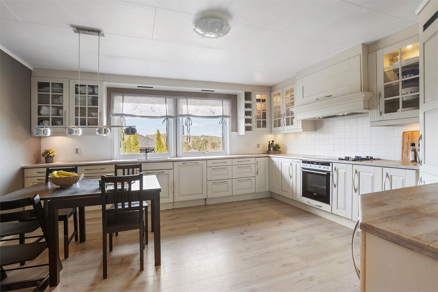 Kjøkkenet har en klassisk innredning med profilerte fronter og rikelig med skap-, samt benkeplass.