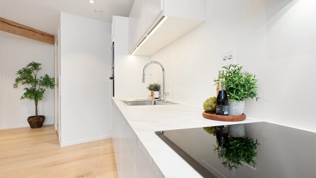 God benkeplass og belysning under overskapene legger til rette for matlaging.