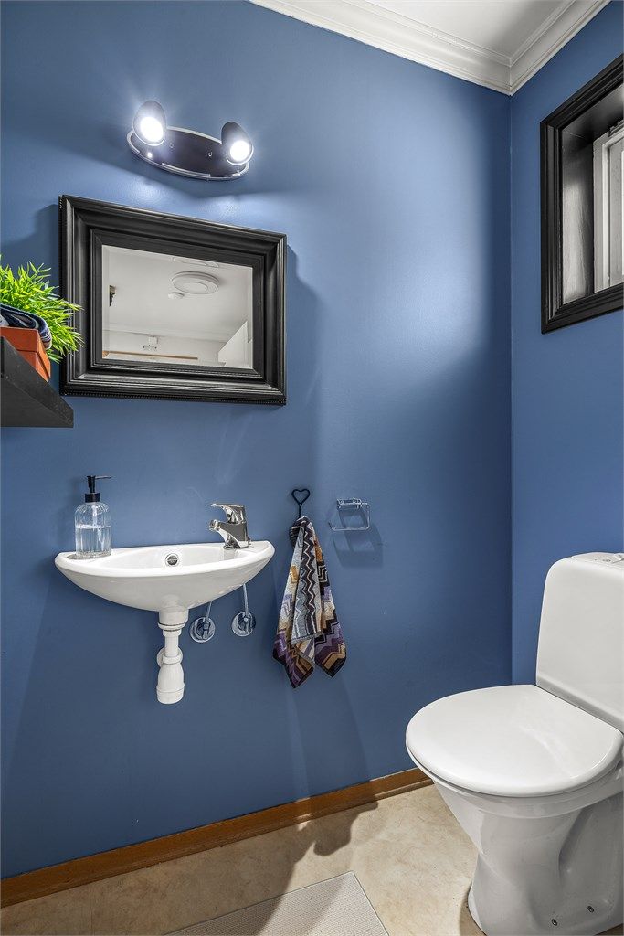 Praktisk toalettrom i første etasje med vegghengt servant og gulvstående toalett.