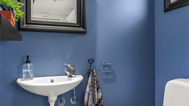 Praktisk toalettrom i første etasje med vegghengt servant og gulvstående toalett.