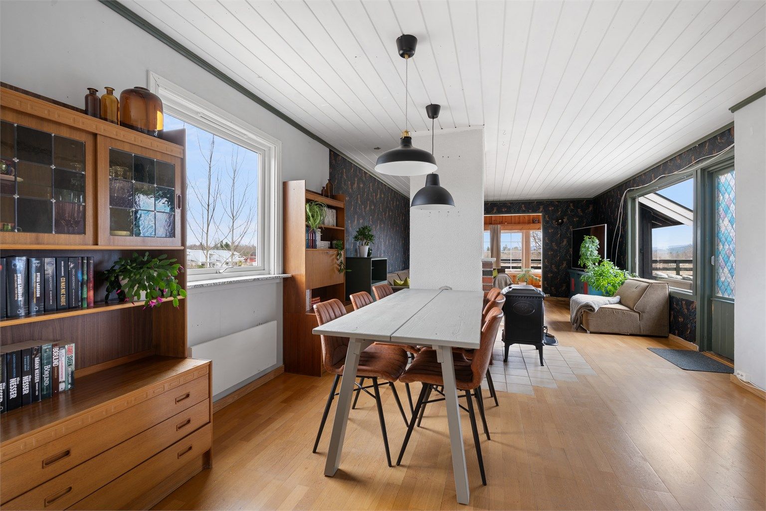 Den åpne planløsningen mellom stue, spisestue og kjøkken skaper en luftig og sosial atmosfære.