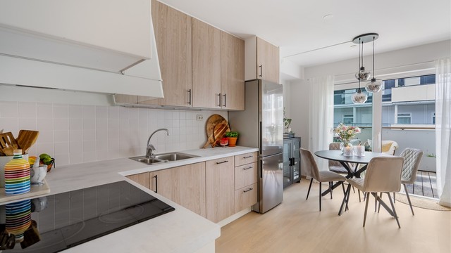 Fliser mellom kjøkkenbenk og overskap bidrar til et helhetlig og pent uttrykk.