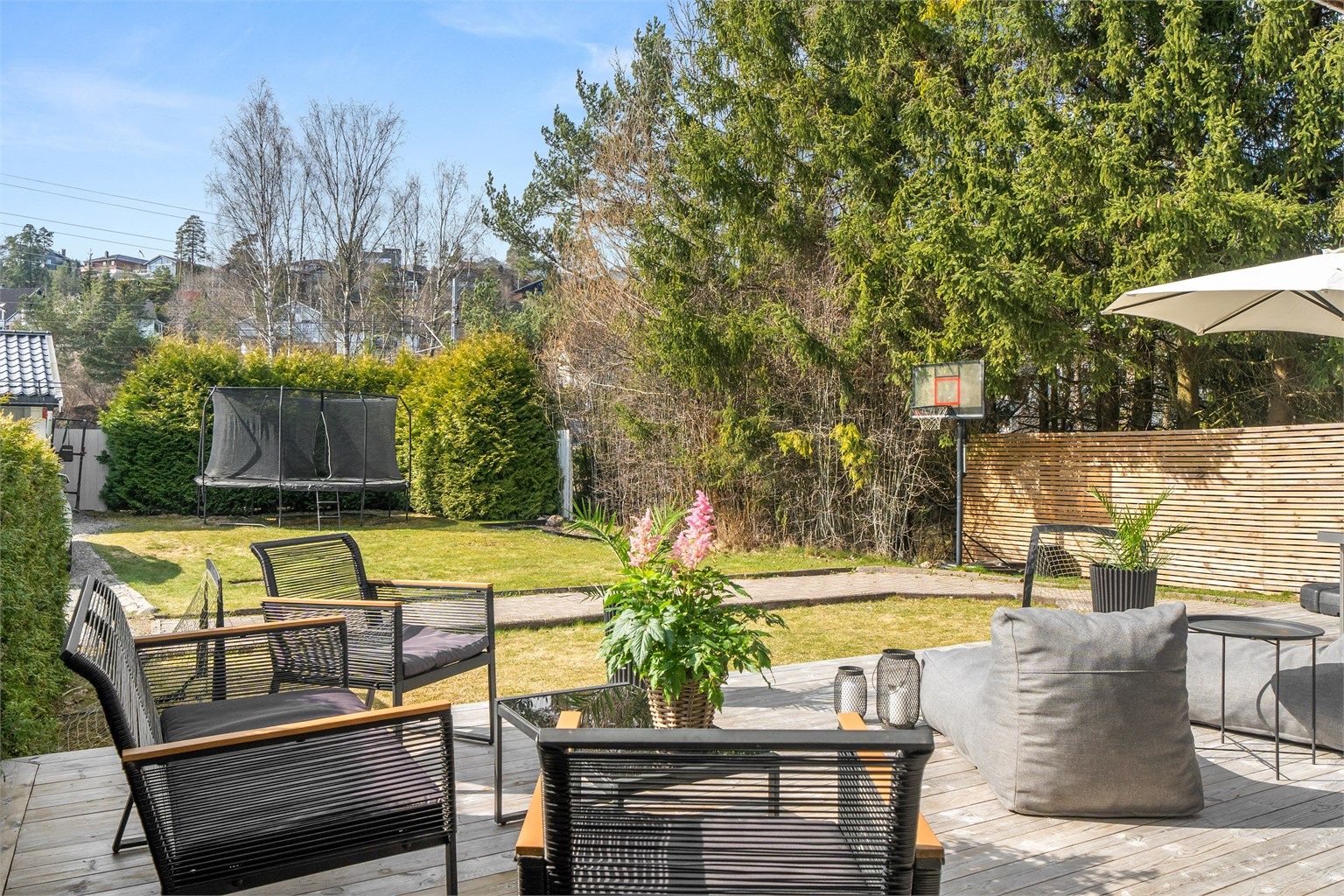 Hage i sameiet sett fra markterrasse. Disponeres og vedlikeholdes i praksis av denne seksjonen.