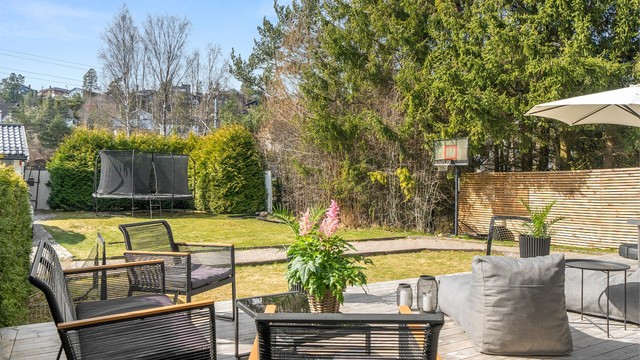 Hage i sameiet sett fra markterrasse. Disponeres og vedlikeholdes i praksis av denne seksjonen.