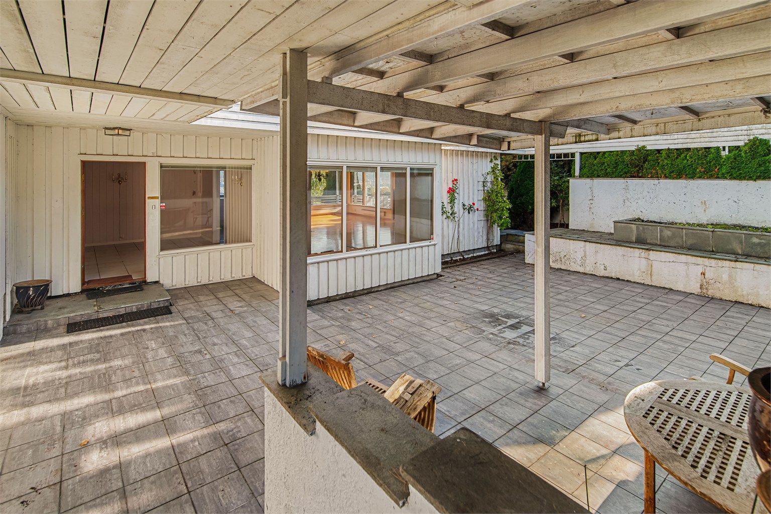 Det overbygde inngangspartiet gir en tørrskodd og lun uteplass.