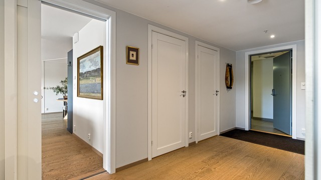 Romslig entré med parkett på gulvet og downlights i tak