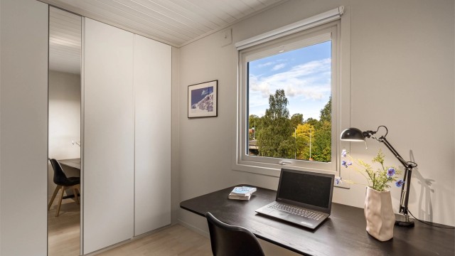 Garderobeskap med speildør og utsikt mot nærområdet fra skriveplassen.