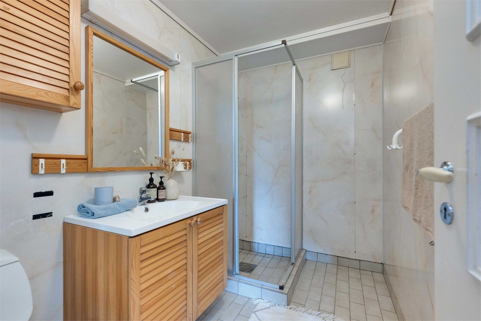 Badet har flislagt gulv med varme, og baderomsplater på veggene
