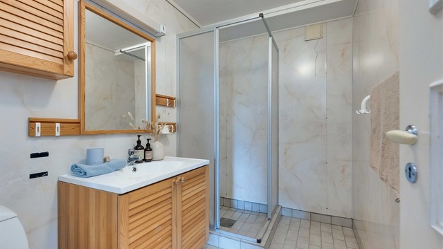 Badet har flislagt gulv med varme, og baderomsplater på veggene