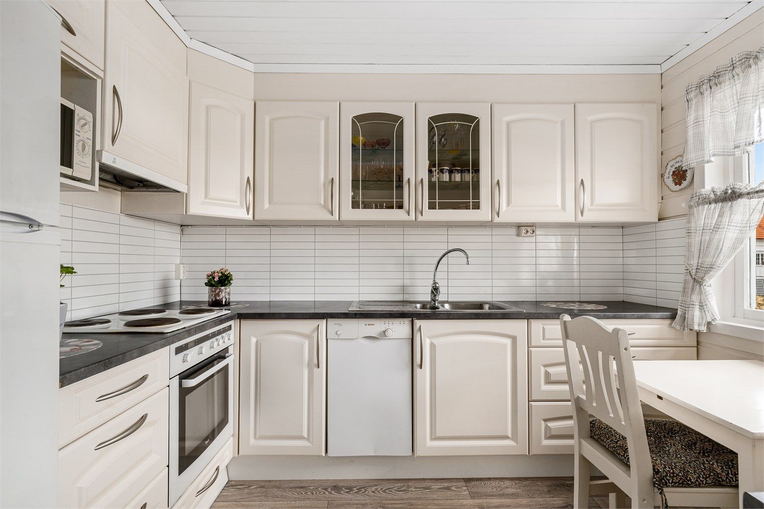 Kjøkkeninnredningen er fornyet med profilerte fronter, benkeplate i laminat og med veggplater mellom benk og overskap.