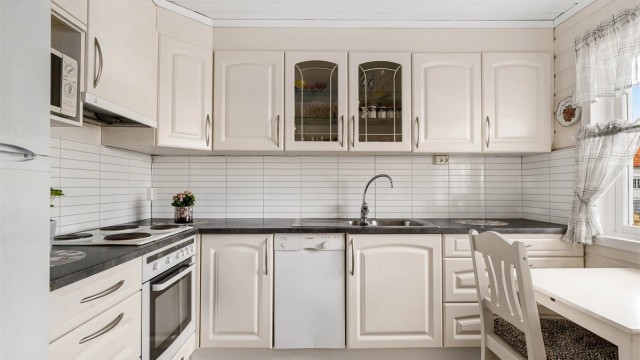 Kjøkkeninnredningen er fornyet med profilerte fronter, benkeplate i laminat og med veggplater mellom benk og overskap.