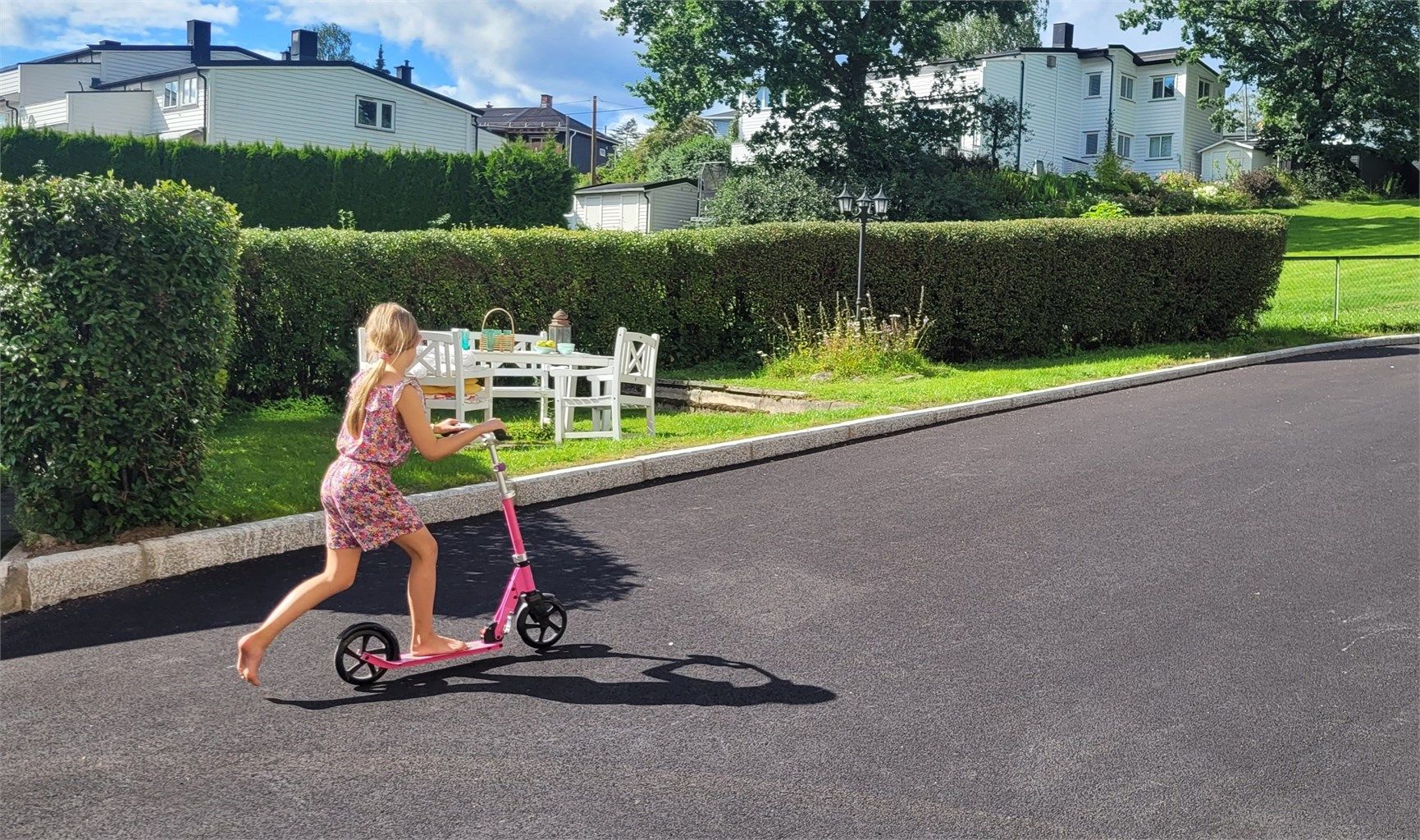 På forsiden av blokken er det satt ut sittegruppe som innbyr til grilling, mens barna sparkesykler eller hopper paradis