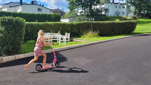 På forsiden av blokken er det satt ut sittegruppe som innbyr til grilling, mens barna sparkesykler eller hopper paradis