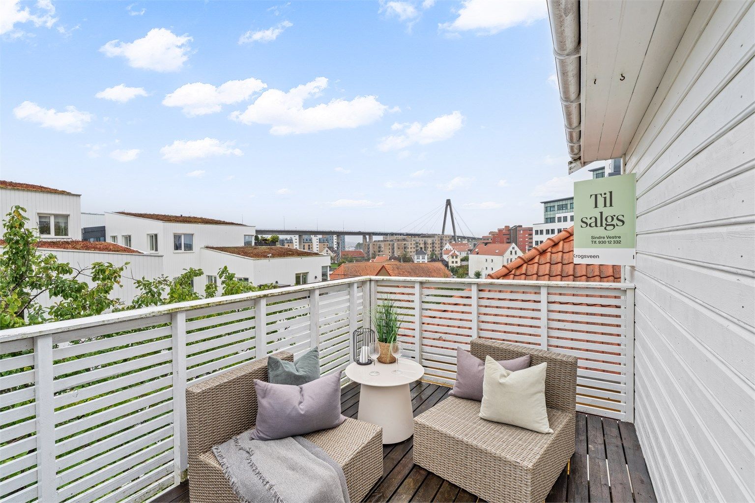 Verandaen utenfor stuen har terrassebord i tre og åpent utsyn over nabolaget.