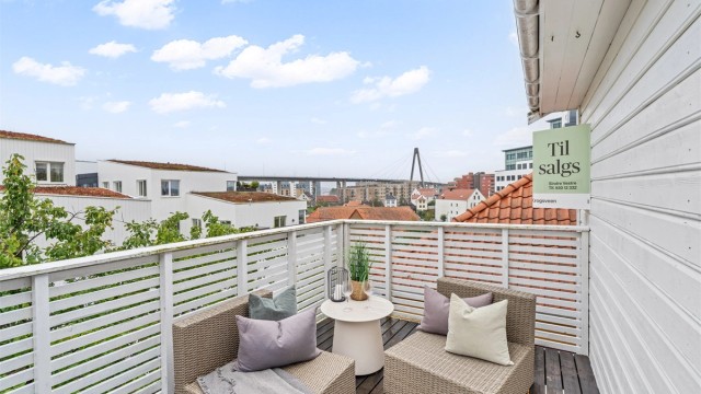 Verandaen utenfor stuen har terrassebord i tre og åpent utsyn over nabolaget.