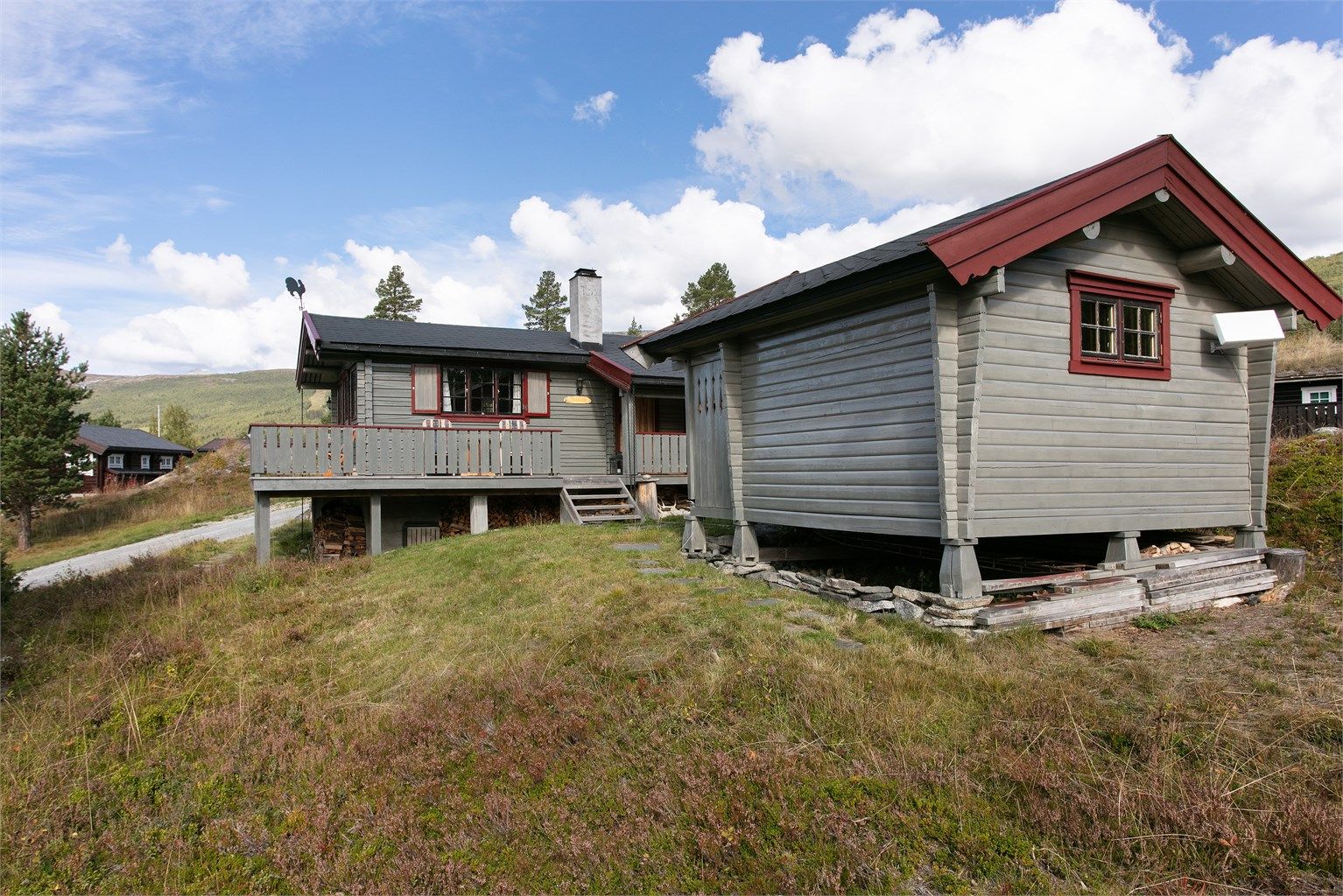 Bygningene er fundamentert på pilarer og ringmur, tilpasset det skrånende terrenget.