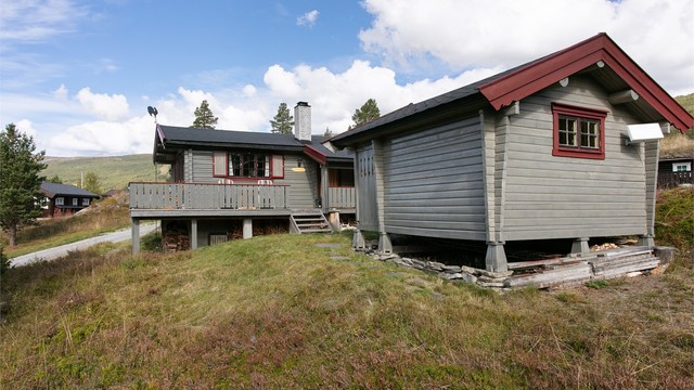 Bygningene er fundamentert på pilarer og ringmur, tilpasset det skrånende terrenget.